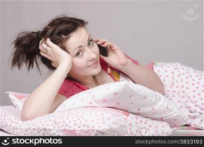 The girl lying in bed and talking on the phone