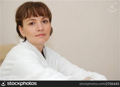 The girl on a bed. It is dressed in a white dressing gown, age of 25 years