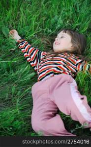 The girl on a green grass. The weakened condition of the small child