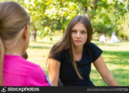 The girl on a picnic listens attentively to the interlocutor