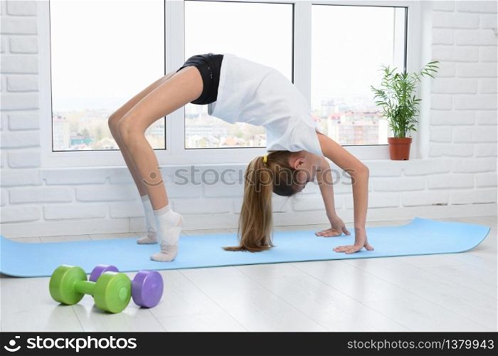 The girl performed the bridge exercise, doing sports at home in self-isolation mode