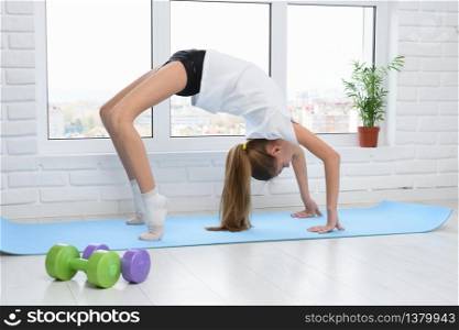 The girl performed the bridge exercise, doing sports at home in self-isolation mode