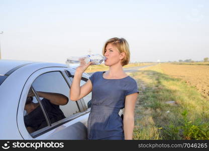 The girl quenches his thirst. Blonde drinks water from a plastic bottle.. Slavyansk-on-Kuban, Russia - September 17, 2017: The girl quenches his thirst. Blonde drinks water from a plastic bottle.