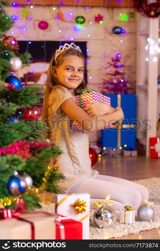 The girl received the coveted gift and happily looks into the frame