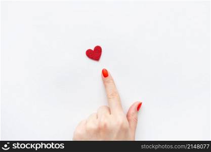 The girl&rsquo;s hand shows a small red heart. Place for an inscription. Health care and world health day concept. The girl&rsquo;s hand shows a small red heart. Place for an inscription. Health care and world health day concept.