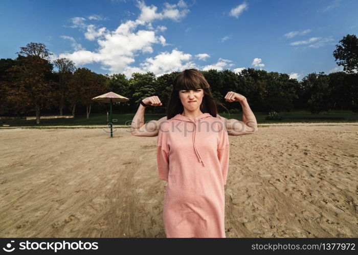 The girl shows her muscles. A woman in a summer dress shows her biceps. Strong brunette. Slender girl with strong hands. The guy behind the girl shows a biceps. energetic young couple. The girl shows her muscles. energetic young couple. A woman in a summer dress shows her biceps. Strong brunette. Slender girl with strong hands. The guy behind the girl shows a biceps