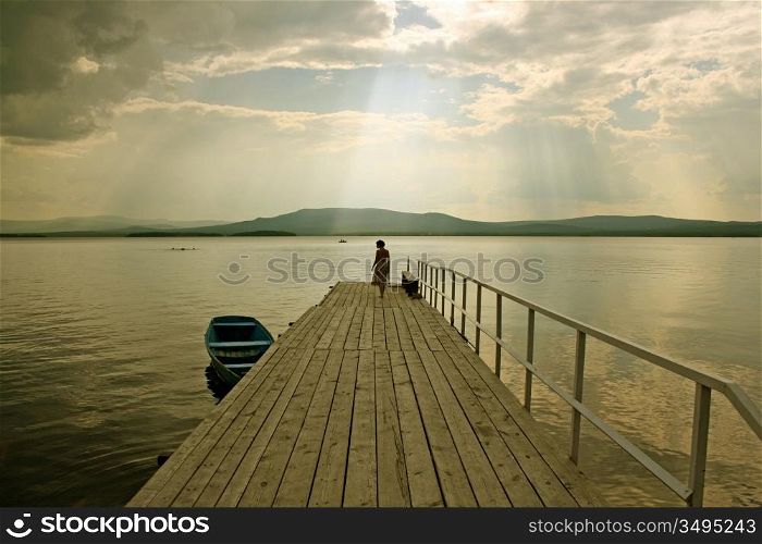 the girl silhouette over the lake background