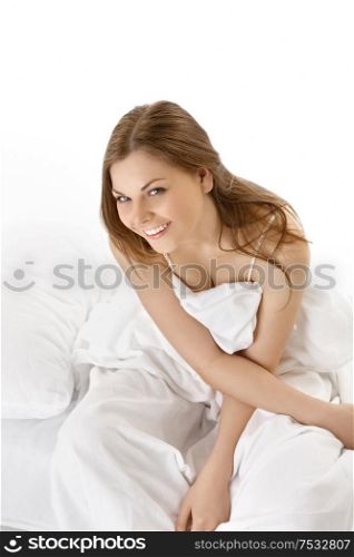 The girl sits in bed and laughs, isolated