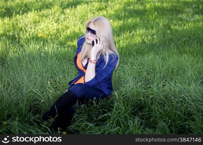 the girl tells by phone on a lawn