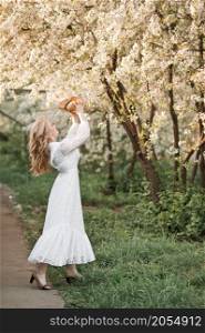 The girl throws her hat in the air in joy.. A girl in a white dress throws a straw hat 2710.