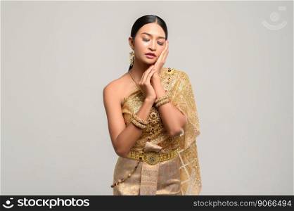 The girl wears Thai dress and hands touch the face.