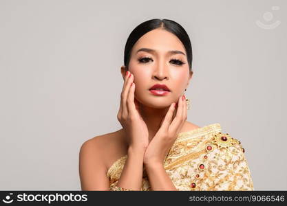 The girl wears Thai dress and hands touch the face.