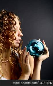 The girl with a magic New Year&acute;s sphere is very surprised holidays