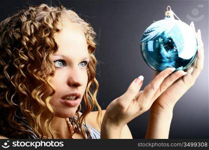 The girl with a magic New Year&acute;s sphere is very surprised holidays
