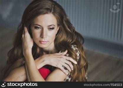 The girl with brown hair hugging herself shoulders.. Close-up portrait of long-haired slender girl 6958.