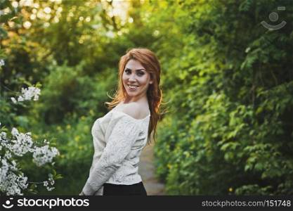 The girl with developing hair.. Girl smiles happily on the background of green trees 6200.