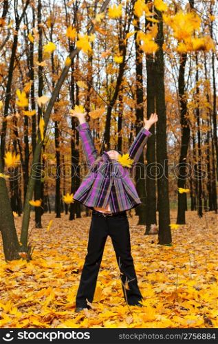 The girl with the lifted hands autumn forest. Falling yellow leaf