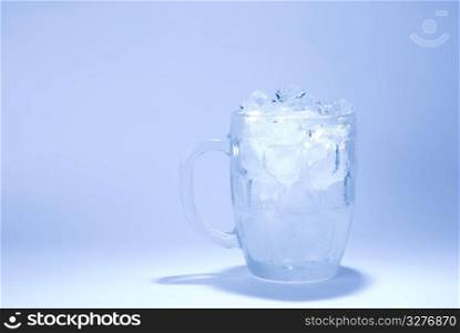 the glass full of ice cube with blue background