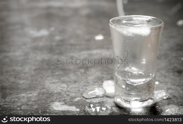 The glass of cold vodka. On the stone table.. The glass of cold vodka.