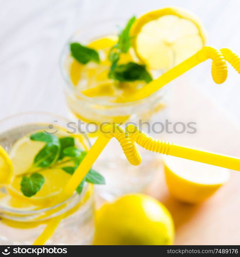 The glasss of mojito with lemon and drinking straw. Glasss of mojito with lemon and drinking straw