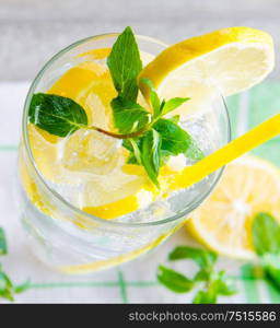 The glasss of mojito with lemon and drinking straw. Glasss of mojito with lemon and drinking straw