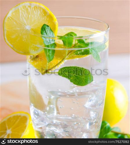 The glasss of mojito with lemon and drinking straw. Glasss of mojito with lemon and drinking straw