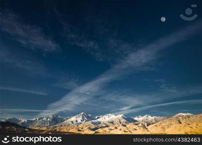 The grand Eastern Sierras captured with a wind swept sky and full moon.