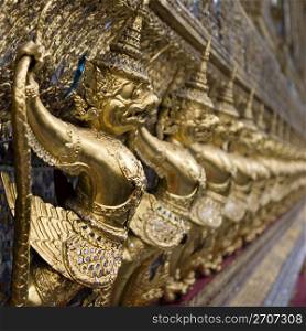 The Grand Palace. Temple of the Emerald Buddha. Gold ornamental patter statuettes. Temple of the Emerald Buddha