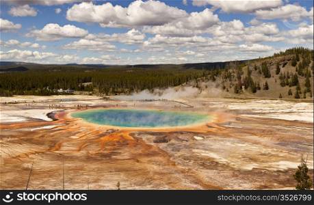 The Grand Prismatic Spring in Yellowstone National Park is the third largest hot spring in the world. With patterns of algae radiating from the dark blue pool, it is a colorful view.