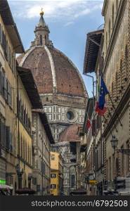 The great dome of the Duomo (Cattedrale di Santa Maria del Fiore) seen from a side street off Piazza Duomo in Florence in Tuscany, Italy. Construction began in 1296 in the Gothic style to the design of Arnolfo di Cambio and completed structurally in 1436 with the dome engineered by Filippo Brunelleschi. A UNESCO World Heritage Site.