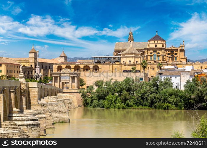 The Great Mosque (Mezquita Cathedral) and Roman Bridge on Guadalquivir river in Cordoba in a beautiful summer day, Spain