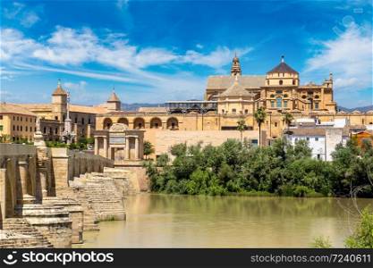 The Great Mosque (Mezquita Cathedral) and Roman Bridge on Guadalquivir river in Cordoba in a beautiful summer day, Spain