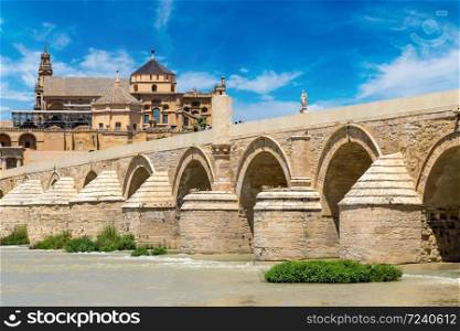 The Great Mosque (Mezquita Cathedral) and Roman Bridge on Guadalquivir river in Cordoba in a beautiful summer day, Spain