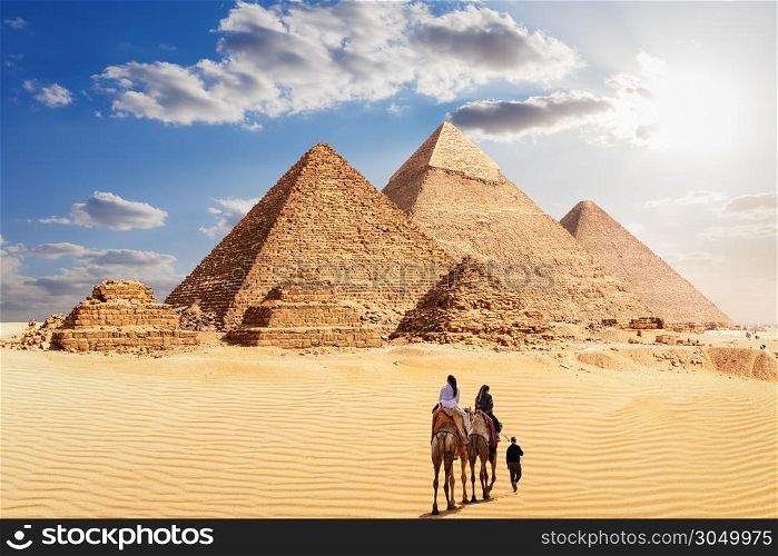 The Great Pyramids of Giza and the bedouins under the desert sun, Egypt.. The Great Pyramids of Giza and the bedouins under the desert sun, Egypt