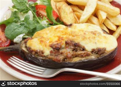 "The Greek dish of aubergines stuffed with minced beef, onion and tomatoes, topped with bechamel sauce and cheese, served with a salad of rocket, lettuca and tomato, and french fried potato chips. The dish is called melitzanes papoutsakia, or "aubergine little-shoes""
