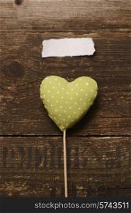 the green heart of the fabric on a dark wooden background. Valentine&#39;s day.