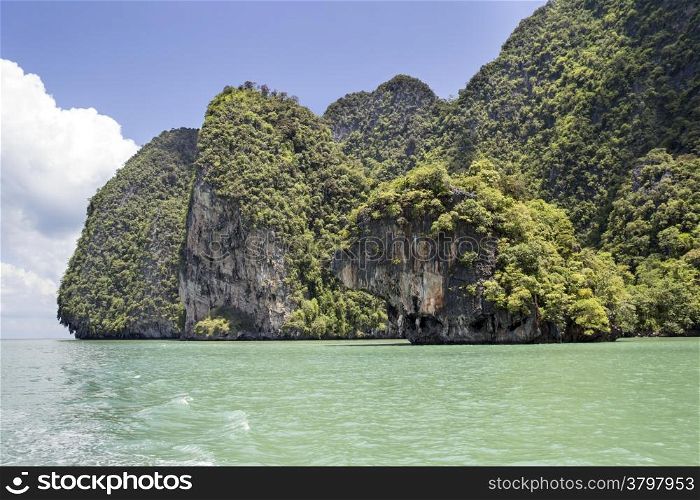 The green waters surrounding the limestone cliffs of Koh Phanak in Phang Nga Bay, Thailand