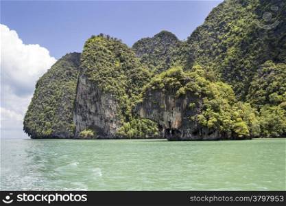 The green waters surrounding the limestone cliffs of Koh Phanak in Phang Nga Bay, Thailand