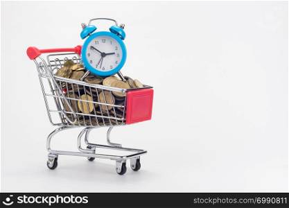 The grocery cart of the store is filled with coins, with a small table clock on top