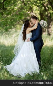 the groom and the bride are walking in the forest on a bright day