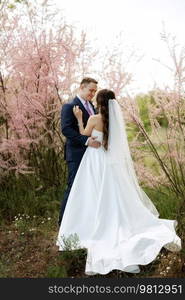 the groom and the bride are walking in the forest on a bright day