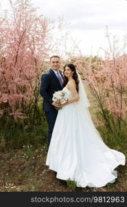 the groom and the bride are walking in the forest on a bright day