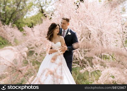 the groom and the bride are walking in the forest on a bright day