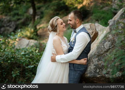 the groom and the bride are walking in the forest on a bright day