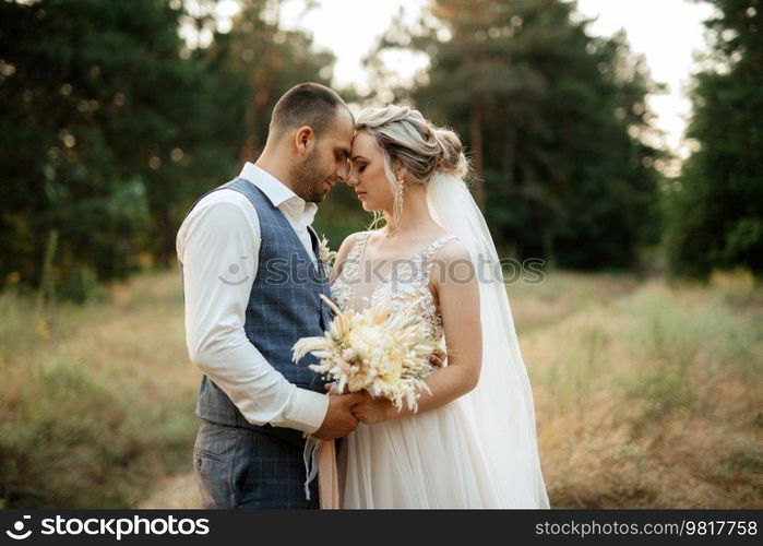 the groom and the bride are walking in the forest on a bright day