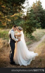 the groom and the bride are walking in the forest on a bright day