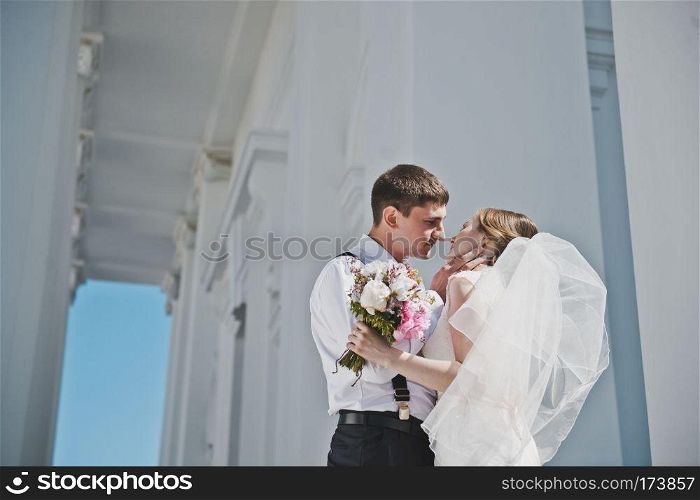 The groom embraces the bride with the white columns.. Embrace amidst the white columns 3889.