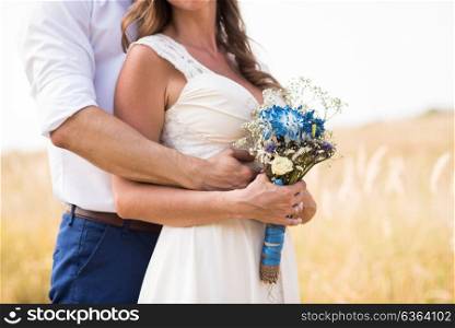 the groom hands the bride hugging on the background fields, and the bride holds a wedding bouquet