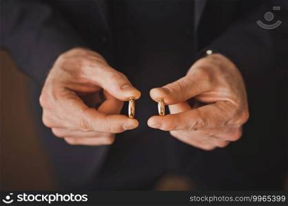The groom holds gold wedding rings in his hands.. Gold rings in the hands of the groom 2501.