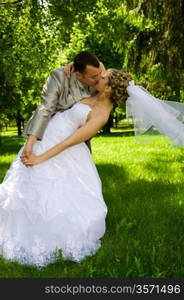 The groom holds the bride in park